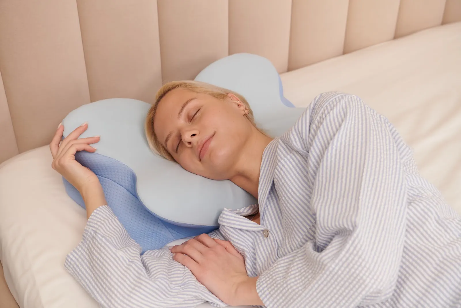 Person resting with a contoured ergonomic pillow